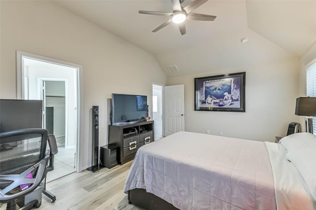 An alternate view of the primary bedroom reveals the entrance into the en-suite bath and generous walk-in closet. | Image 19