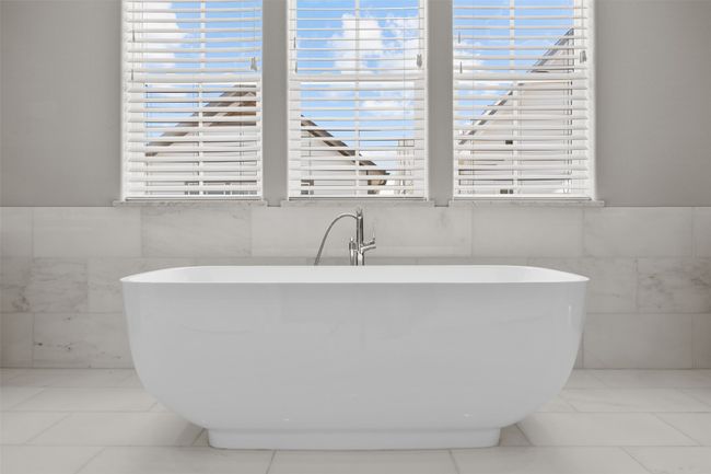 Full bathroom with tile walls, a freestanding tub, healthy amount of natural light, and wainscoting | Image 20