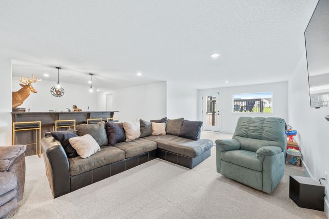 Living area with carpet, recessed lighting, and bar | Image 26