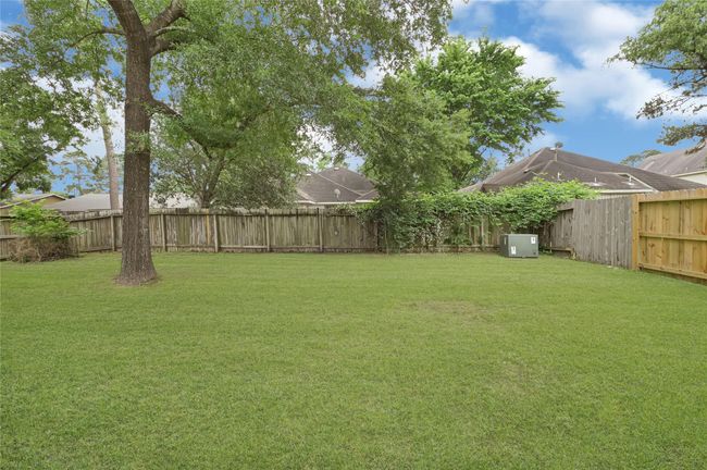 Large backyard with mature tree and wooden fence. *Grass edited* | Image 31