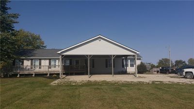 Front view of property featuring a large partially covered porch and a deck | Image 1