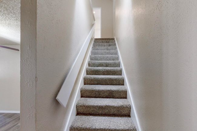 Stairway featuring wood finished floors and a textured wall | Image 7