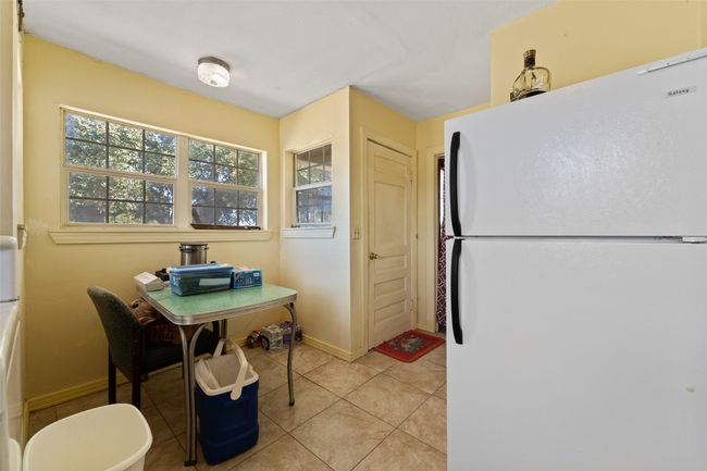 Kitchen with light tile patterned flooring, plenty of natural light, freestanding refrigerator, and baseboards | Image 10