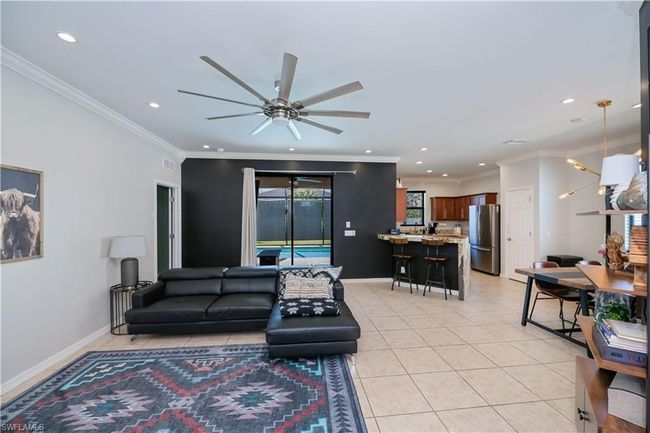 Living area featuring ceiling fan, visible vents, light tile patterned floors, ornamental molding, and recessed lighting | Image 27