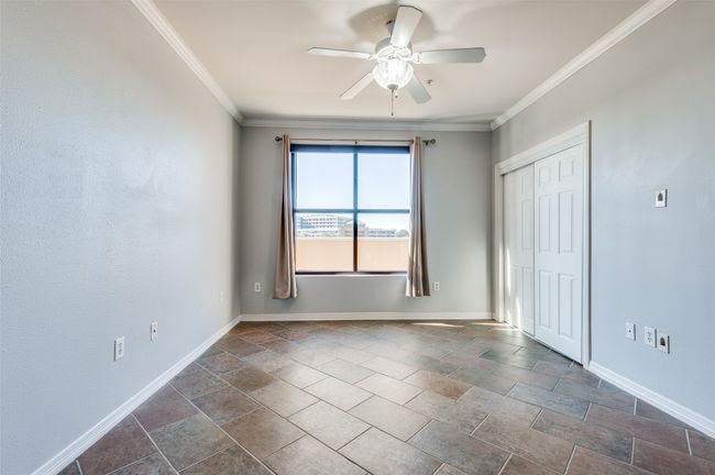 Secondary bedroom with ceiling fan, crown molding, and ceramic tile flooring | Image 21