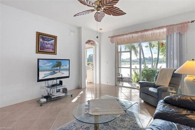 Living room with tile floors, ceiling fan, and a healthy amount of sunlight | Image 9