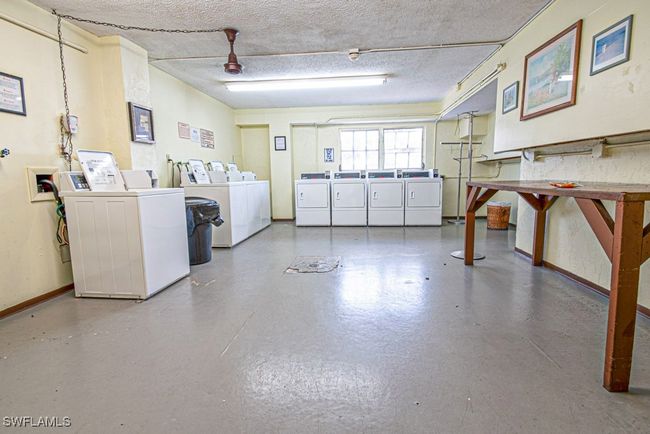 Common laundry area with a textured ceiling, baseboards, and washer and clothes dryer | Image 23