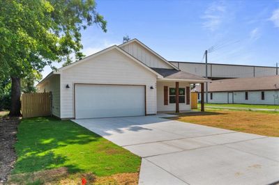 Ranch-style house featuring a garage and a front lawn | Image 3