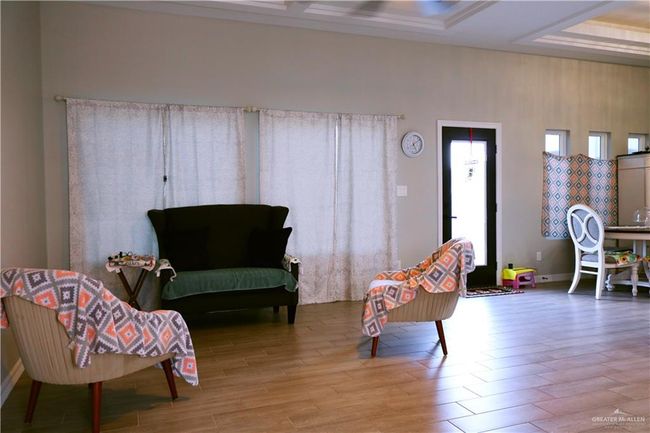 Living area with wood finished floors and a raised ceiling | Image 9