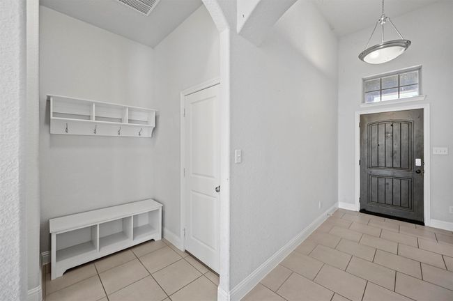 Entrance foyer featuring light tile patterned floors, visible vents, arched walkways, and baseboards | Image 35