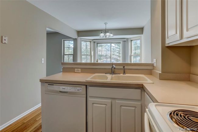 Light filled kitchen with hardwood floors and snack bar, perfect place to cook and entertain. | Image 9