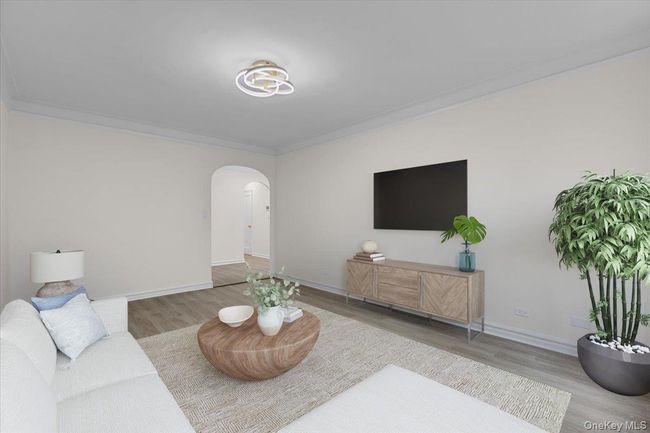 Living area featuring arched walkways, ornamental molding, and wood finished floors | Image 5