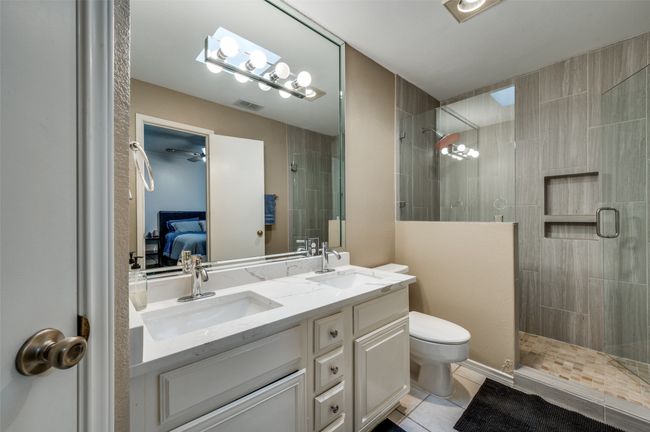 Bathroom featuring tile patterned flooring, vanity, an enclosed shower, and toilet | Image 9