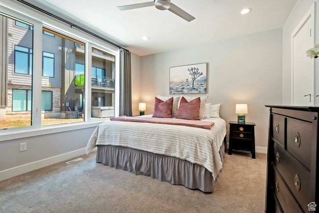 Bedroom featuring baseboards, visible vents, light colored carpet, and multiple windows | Image 19