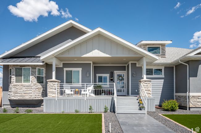 Craftsman-style home with stone siding, covered porch, and a front yard | Image 7