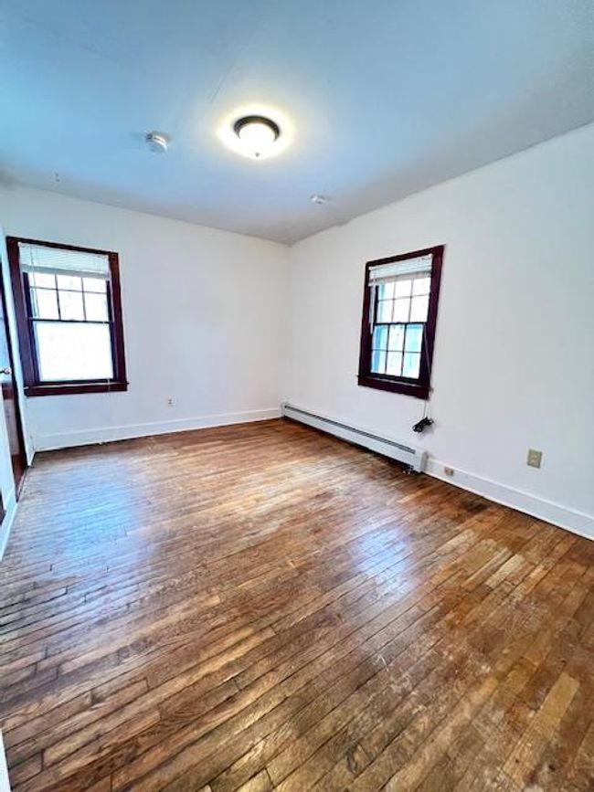 Unfurnished with light wood- flooring, a wealth of natural light, and a baseboard radiator | Image 5