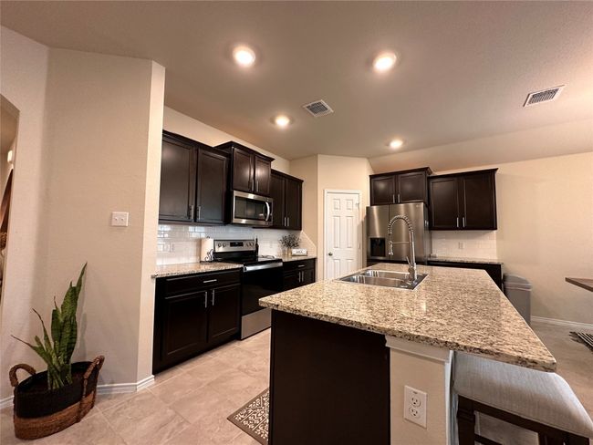 Kitchen featuring appliances with stainless steel finishes, a sink, backsplash, baseboards, and recessed lighting | Image 21