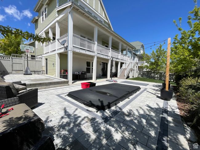 Rear view of property with stairway, fence, and a spa/patio area | Image 72