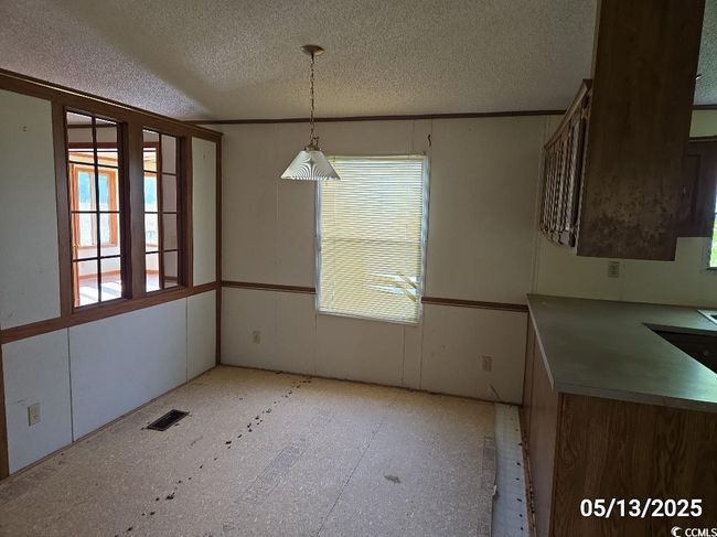 Unfurnished dining area featuring plenty of natural light and a textured ceiling | Image 23