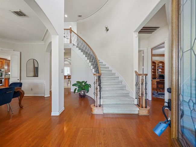 Elegant curved staircase with intricate ironwork, offering a grand entrance and timeless charm. | Image 5