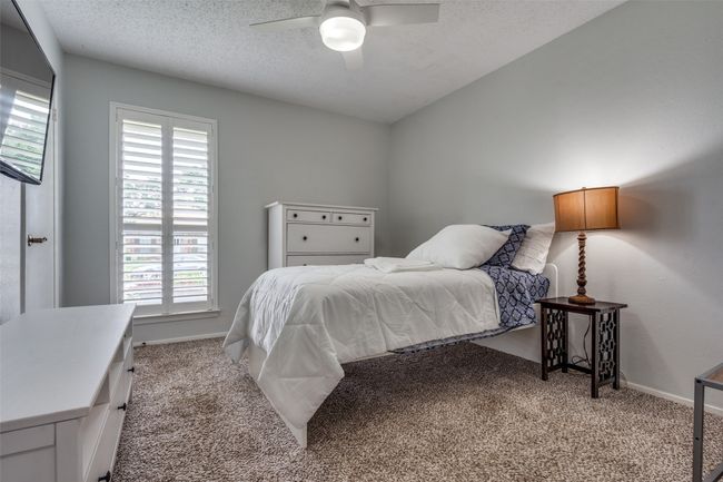 Bedroom featuring carpet flooring, a textured ceiling, and ceiling fan | Image 18