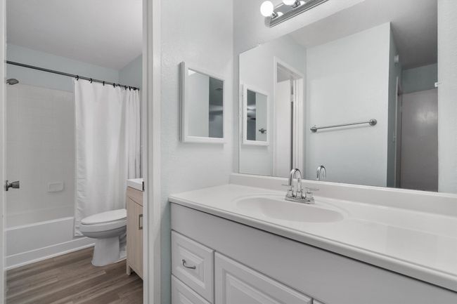 Bathroom featuring vanity, shower / bath combo, and wood finished floors | Image 23