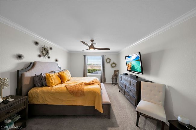 Carpeted bedroom featuring ceiling fan and crown molding | Image 39