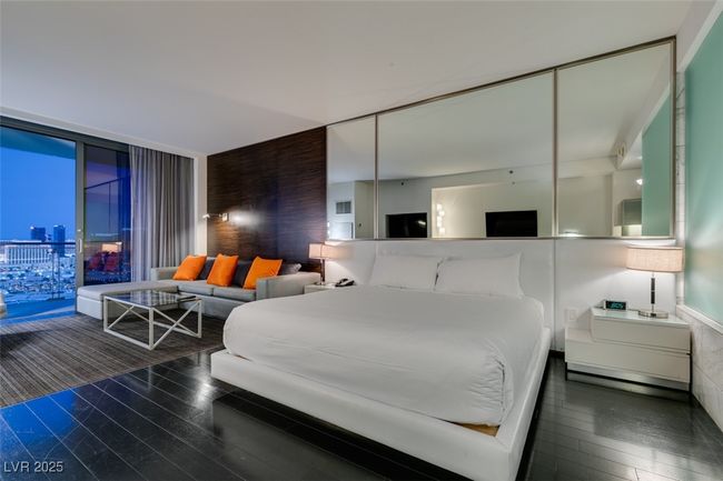 Bedroom with wood finished floors and expansive windows | Image 9