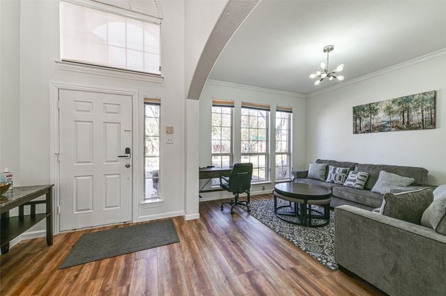 Entryway with dark hardwood / wood-style floors, a notable chandelier, and a healthy amount of sunlight | Image 4