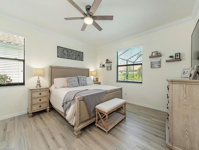 Bedroom featuring ornamental molding, light wood-type flooring, multiple windows, and baseboards | Image 5