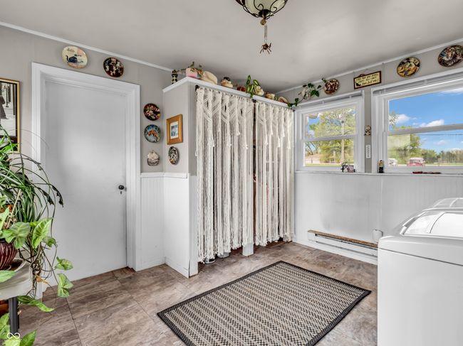 laundry room featuring washer / dryer, laundry area, baseboard heating, and wainscoting | Image 20