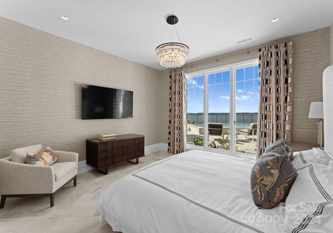 This inviting lake-level bedroom overlooks both the pool and lake for unending water views. It is equipped with a private en-suite. | Image 38