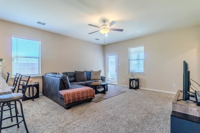 Carpeted living room featuring a wealth of natural light and ceiling fan | Image 12