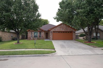 Ranch-style house with cooling unit, a garage, and a front yard | Image 2