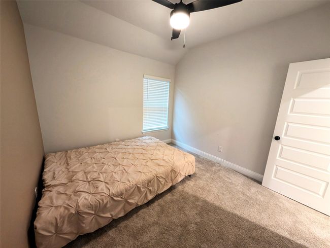 Bedroom featuring baseboards, a ceiling fan, lofted ceiling, and carpet floors | Image 8