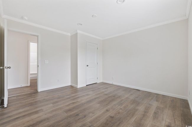 Empty room featuring wood finished floors, ornamental molding, and a smoke detector | Image 20