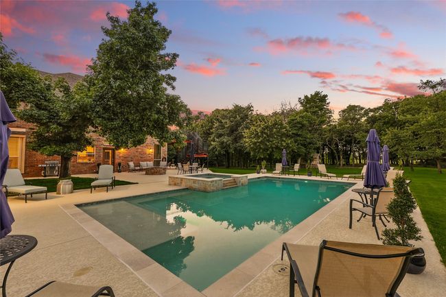 Twilight view of swimming pool with hot tub, a patio with grilling area | Image 36