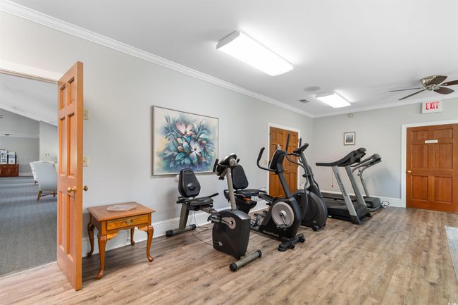 Workout room with ornamental molding, light wood finished floors, and a ceiling fan | Image 35