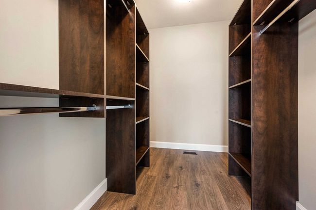 Spacious closet with dark wood-style floors | Image 25
