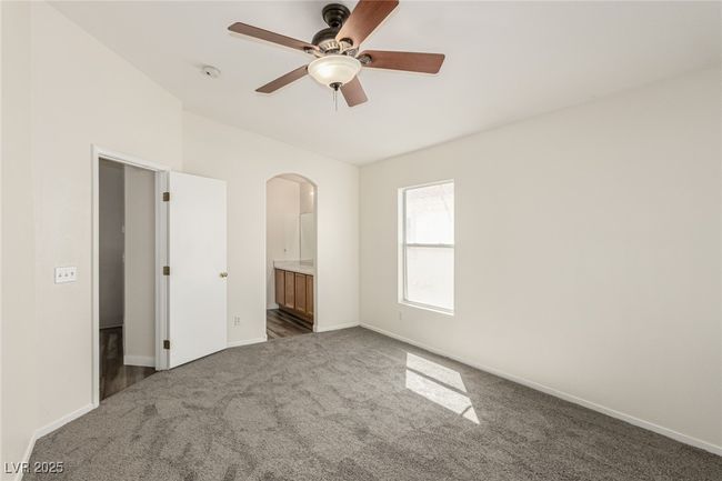 Primary featuring arched walkways, baseboards, dark carpet, and ensuite bathroom | Image 13