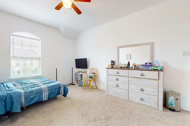 Bedroom featuring ceiling fan, carpet flooring, vaulted ceiling, and baseboards | Image 36