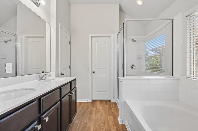 Primary bath with a soaking tub, a walk-in shower, light wood-type flooring, and double vanity | Image 21