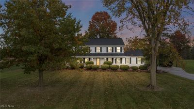 Colonial home featuring covered porch and a lawn | Image 2