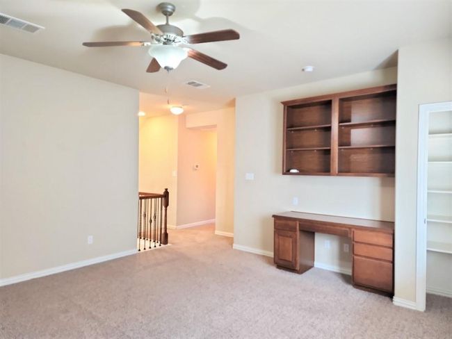 Unfurnished office featuring built in study area, light carpet, a ceiling fan, and baseboards | Image 22