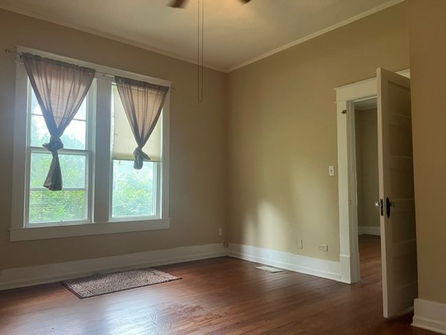 Empty room with crown molding, dark wood-type flooring, and ceiling fan | Image 17