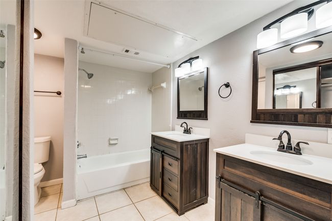 Bathroom featuring two vanities, tile patterned floors, and shower combination | Image 11