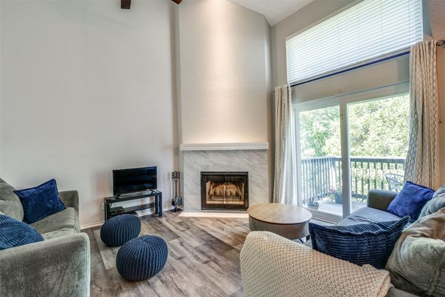 Living area with a fireplace, a high ceiling, and wood finished floors | Image 5