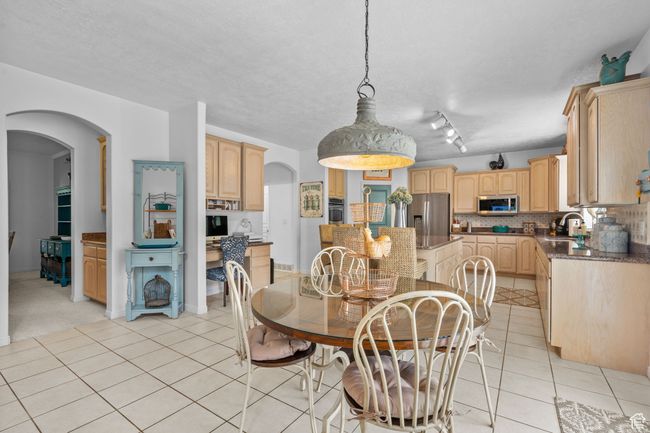 Dining area with arched walkways, a textured ceiling, and light tile patterned flooring | Image 16