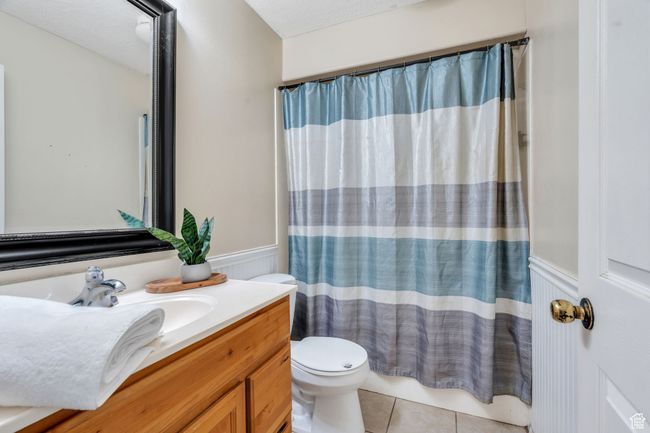 Full bathroom with vanity, a wainscoted wall, and tile patterned flooring | Image 9