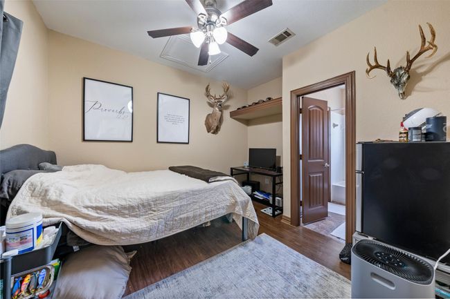 Bedroom with wood finished floors, a ceiling fan, and freestanding refrigerator | Image 16